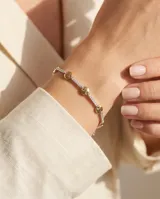 Pulsera de plata 925 con baño de oro, compuesta por una cadena de eslabones rectangulares pavimentados con circonias blancas, intercalados con discos dorados lisos.