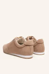 Zapatilla de gamuza color bordó con cordones bicolores, interior de cuero vacuno y suela de caucho blanca y beige.