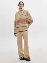 Pantalón de jogging rojo con textura tipo terciopelo, calce ancho y suelto, con detalle de pespuntes a los lados.