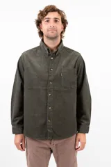 Camisa verde oliva de pana de algodón, corte recto, manga larga, cuello abotonado y bolsillo en el pecho.