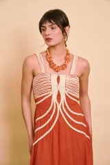 Vestido largo color terracota de tirantes, con detalles de cordones decorativos en color crudo en la parte frontal y falda amplia de corte fluido.