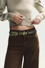 Jersey de punto con cuello en V y manga larga. Presenta un diseño versátil con detalles de acabados desmontables mediante botones en la parte inferior y en los hombros.