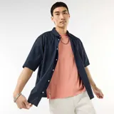 Camisa de manga corta azul marino confeccionada en popelín, con cuello camisero clásico y cierre frontal de botones.