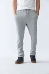 Pantalón de jogging gris melange, corte regular, con cintura elástica ajustable con cordón, bolsillos laterales y trasero, y logo de goma en la pierna.