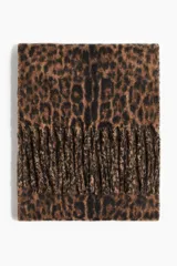 Bufanda de tejido suave y cepillado con estampado de leopardo en tonos marrón y negro. Presenta flecos largos en los bordes.