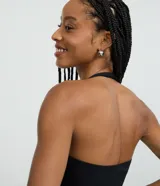 Blusa frente única de microfibra color beige, con escote cuadrado y breteles que se ajustan al cuello. Diseño sin mangas y espalda descubierta.