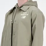 Campera tipo coach color verde oliva, con cierre frontal de botones a presión, cuello camisero y logo de New Balance estampado en el pecho. Confeccionada en tejido ligero de poliéster reciclado, presenta un ajuste holgado y diseño minimalista.