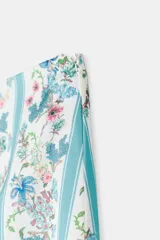 Falda midi de tiro medio, corte tubo y abertura en la espalda. Presenta un estampado de flores combinado con rayas verticales celestes y blancas.