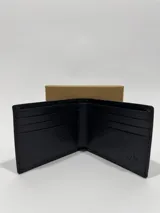 Billetera clásica para hombre de cuero vacuno en color marrón oscuro, con diseño plegable y logo de la marca grabado en el frente.