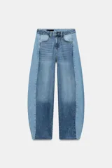 Jeans de tiro medio con diseño barrel y paneles laterales en un tono de denim más claro que contrasta con el centro. Presenta cinco bolsillos, cierre frontal con cremallera y botón, y bajo con acabado sin costura.