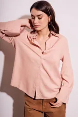 Camisa color salmón de corte oversize, confeccionada en lino y viscosa, con cuello clásico, cierre frontal con botones y mangas largas con puños anchos.