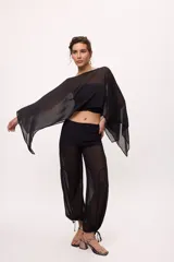 Pantalón ancho de seda color amarillo, estilo parachute o globo, con talle alto y cordones ajustables en los tobillos.