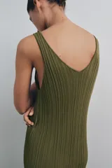 Vestido midi de punto acanalado color verde oliva, con escote en V y tirantes anchos. La parte superior presenta un diseño de tejido rib, mientras que la parte inferior está terminada con una aplicación de encaje transparente al tono.