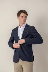 Saco azul marino de corte slim fit confeccionado en tencel, con solapa de muesca, cierre de dos botones, bolsillo de parche en el pecho y bolsillos laterales con solapa.
