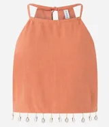 Blusa color ladrillo con escote halter, sin mangas, lazo en la espalda y flecos con caracolas en la cintura.
