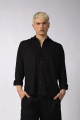 Camisa de manga larga color negro, con cuello abierto y calce relajado.