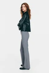Pantalón sastrero gris de tiro alto, corte ajustado y piernas acampanadas, con trabillas para cinto y bolsillos traseros insertados.