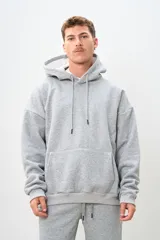 Canguro gris melange con capucha, cordones ajustables, bolsillo tipo canguro y puños y cintura acanalados.