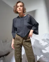 Pantalón verde militar tornasolado de algodón brillante, corte a la cintura y piernas rectas con textura de tableado central.