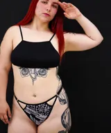 Pantie colaless con estampado abstracto en blanco y negro, con tiras finas y argollas metálicas en los laterales.