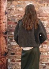 Chaqueta de mezcla de lana con diseño de pata de gallo en tonos marrones y verdes, corte oversize, cuello camisero, manga larga, cierre frontal con botones y dos bolsillos laterales.