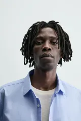 Camisa slim fit de algodón color celeste, con cuello italiano, manga larga y puños con botón. Cierre frontal de botonadura.