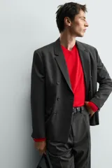 Blazer de corte regular confeccionada en tejido con lana, con diseño de botonadura cruzada. Presenta cuello con solapas de pico, manga larga con puños abotonados, bolsillos de solapa en la cadera y abertura central en la espalda.