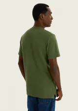 Remera de manga corta color beige, con cuello redondo y cartera frontal con tres botones. Diseño básico y entallado de textura suave.