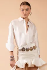Camisa de mujer color blanco, de corte clásico con cuello camisero, cierre frontal de botones y mangas largas con puños anchos. Confeccionada en tela de acabado satinado con caída fluida y elegante.