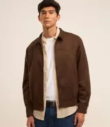 Campera masculina de estilo casual, confeccionada en tejido de poliéster con elastano. Presenta cuello inglés, cierre frontal por cremallera, bolsillos laterales y detalles de recortes en el pecho. El bajo cuenta con ajuste elástico para mayor comodidad.