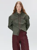 Camisa western de algodón grueso color verde militar, con corte holgado y aplicaciones de hilo en contraste en el pecho, la cartera de botones y los puños.