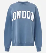 Buzo cerrado de fleece color azul, con cuello redondo, mangas largas, puños y ruedo ajustados. Presenta estampa frontal con la palabra "LONDON" en letras blancas con borde oscuro.
