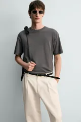 Camiseta de corte relaxed fit, confeccionada en mezcla de algodón y lino, con cuello redondo y mangas cortas.