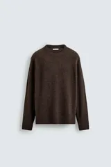 Jersey de corte regular fit, confeccionado en tejido de mezcla de lana con un 5% de cashmere. Presenta cuello redondo, manga larga y acabados en rib en puños y bajo.
