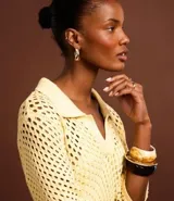 Vestido midi color amarillo pálido con efecto crochet, cuello polo, manga corta y abertura lateral. Confeccionado en algodón BCI más sostenible.