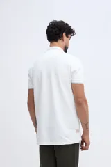Remera polo Brooksfield modelo Calm, color azul marino, de manga corta y tejido de punto piqué de algodón. Cuenta con cuello tipo polo y cierre frontal parcial con ribetes en celeste claro que combinan con el bordado del logo de la marca en el pecho.