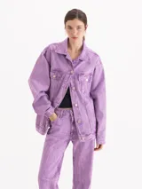Campera oversize de denim de puro algodón, con lavado efecto nevado en tono lila. Cuenta con mangas largas, bolsillos frontales con solapa y cierre de botones metálicos.