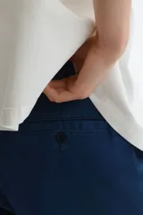 Pantalón de sarga de algodón en color azul marino, con corte relajado, cierre de cremallera y botón, bolsillos laterales al bies y bolsillos traseros insertados con botón.