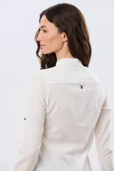 Camisa de lino lisa color celeste, de manga larga con puños abotonados y trabilla para arremangar. Cuenta con cuello clásico, cierre frontal con botones y bolsillos plaqué en el pecho.