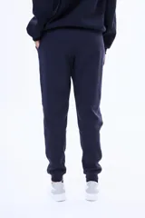 Pantalón de jogging de felpa, color beige, con cintura elástica ajustable mediante cordón y puños acanalados en los tobillos.