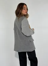 Saco color beige con solapas, cierre de dos botones, bolsillos delanteros con solapa y mangas de punto acanalado.