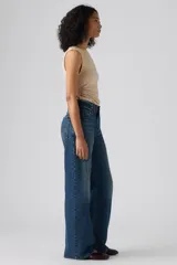 Jeans de denim azul de corte amplio y bota ancha, tiro medio, con efecto ligeramente lavado en las piernas y diseño clásico de cinco bolsillos.