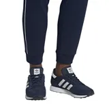 Championes Adidas modelo Forest Grove, color azul marino con las icónicas tres tiras laterales en blanco. Presentan una combinación de gamuza y malla en el exterior, con una entresuela blanca texturizada y suela de goma negra.