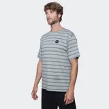 Remera de manga corta con cuello redondo, diseño a rayas horizontales en tonos beige y marrón oscuro, con parche de logo de la marca en el pecho.