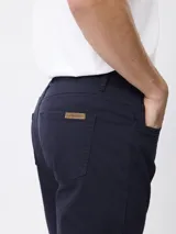 Pantalón de corte recto en color tostado, confeccionado en tejido de algodón con elastano. Presenta cierre frontal con botón y cremallera, además de bolsillos laterales y traseros.