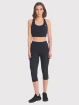 Calza deportiva tipo capri de tiro alto, confeccionada en tejido elástico con ajuste regular y diseño liso.
