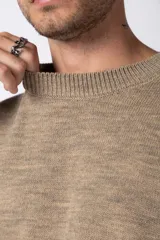 Sweater de punto grueso en color verde oliva, con diseño oversized, cuello redondo y mangas largas con puños acanalados.