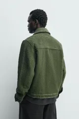 Sobrecamisa de hombre relaxed fit color verde oscuro, confeccionada en tejido de textura efecto toalla. Cuenta con cuello solapa, manga larga con puño abotonado, bolsillos de parche con solapa en el pecho, pespuntes a contraste y cierre frontal con botones.