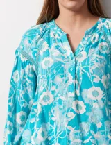 Blusa de gasa estampada marca Zac & Rachel. Tiene cuello a la base, escote en V con apertura y botones. Las mangas son 3/4 con frunce. Tiene detalle de crochet en hombros y delantera.