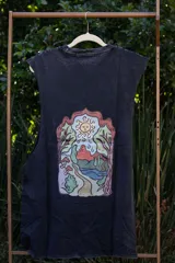 Musculosa sin mangas, color azul celeste con efecto acid wash, cuello redondo y amplias sisas. Presenta un pequeño estampado frontal de tres hongos rojos y blancos con la inscripción "Tuya" debajo.